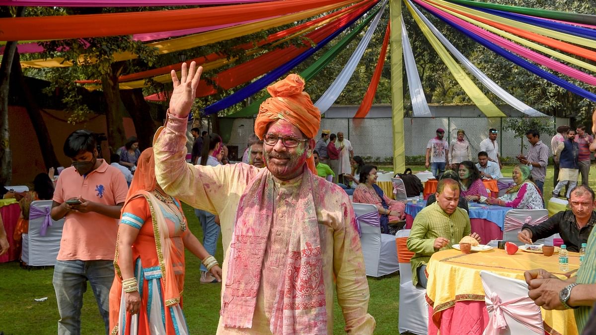 Union Minister Mukhtar Abbas Naqvi gestures for the photographers during the Holi celebrations at his residence in New Delhi. Credit: PTI Photo