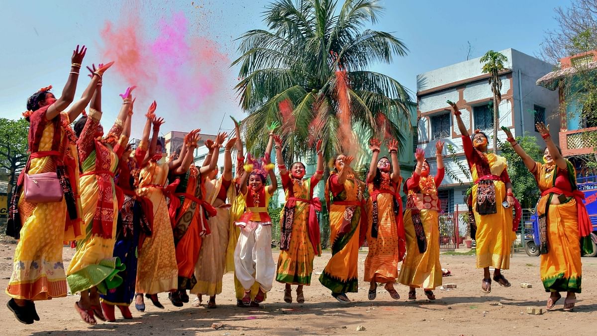 Women play with dry colours as they pose for photographs during the Holi festival, in Dhanbad, Jharkhand. Credit: PTI Photo