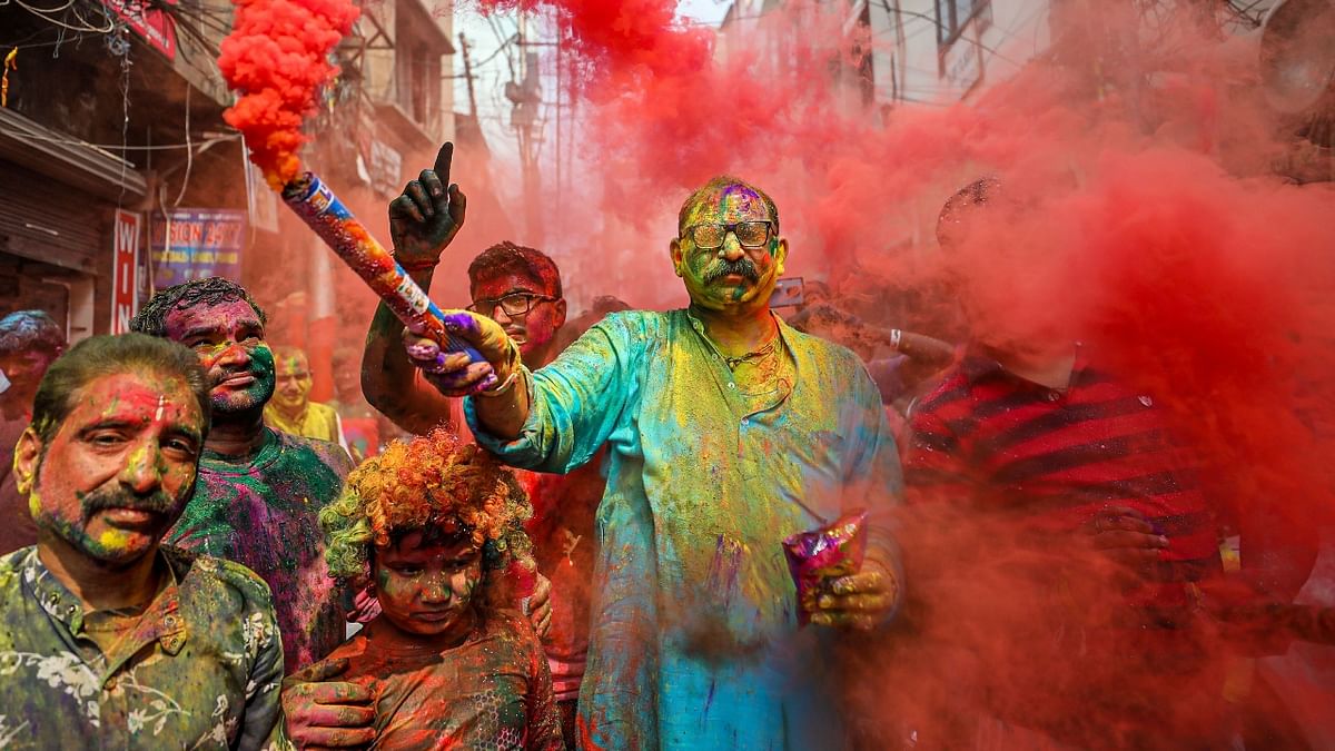People play with dry colours and smoke bombs during the Holi festival, in Jammu. Credit: PTI Photo