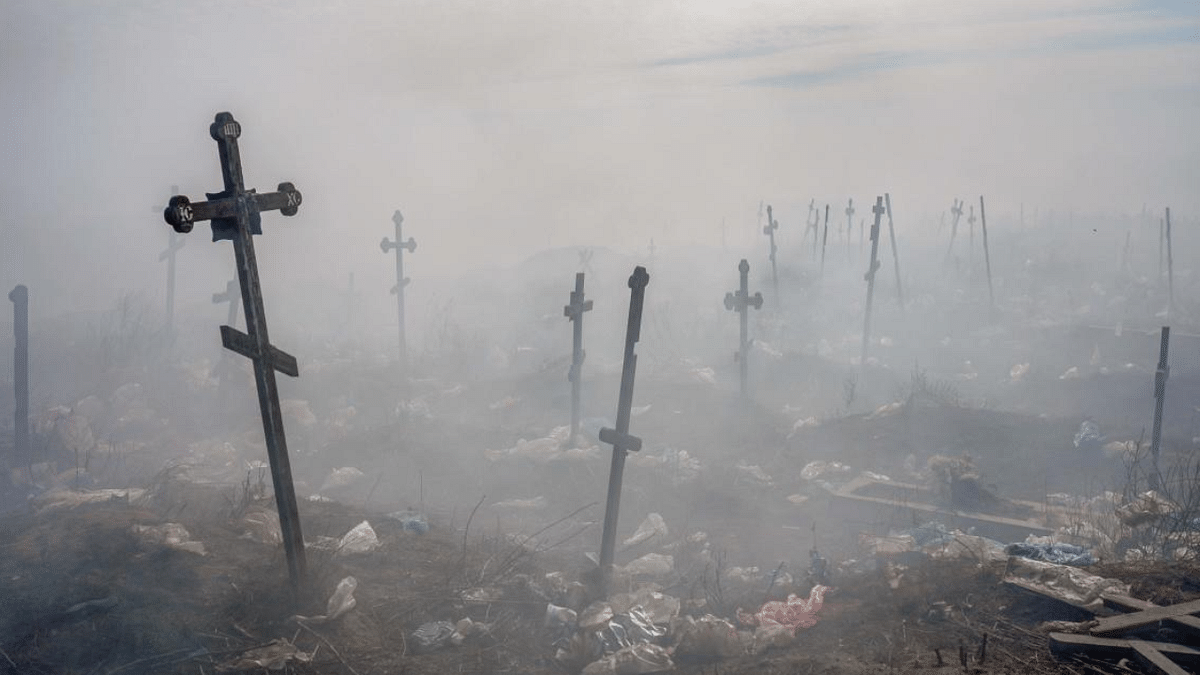 Crosses are pictured under smoke from a garbage in the cemetery of Mykolaiv, southern Ukraine. Credit: AFP Photo