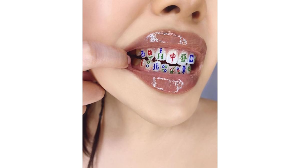MUA MIMI not just limited herself to face paint, she also tried painting her teeth. In this photo, Mimi is seen flaunting her painted teeth. Credit: Instagram/mimles