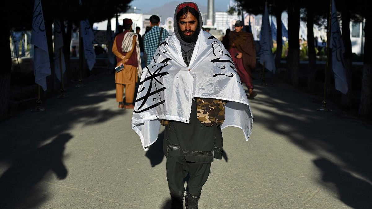 A man wears a flag at the venue for a flag hoisting ceremony of the Taliban flag on the Wazir Akbar Khan hill in Kabul. Credit: AFP Photo