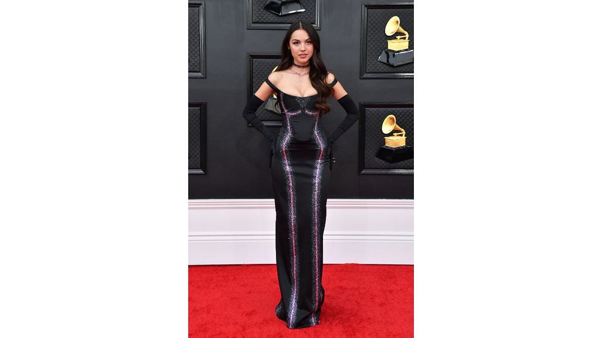 Olivia Rodrigo opted for a body-conscious 90s look in a figure-hugging black Vivienne Westwood gown with pink accents and a choker, finished off with long gloves. Credit: AFP Photo