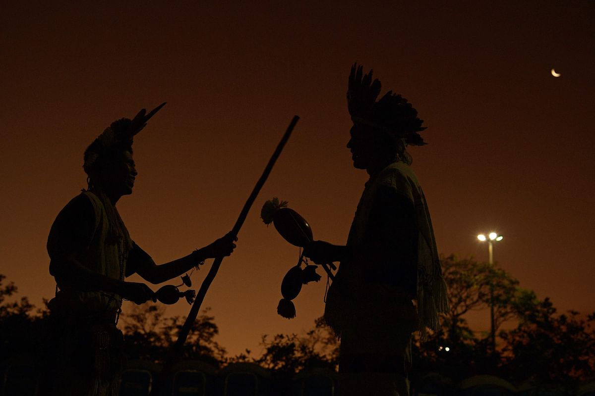 Indigenous men talk during sunset at an indigenous protest camp on the first day of the Terra Livre Indigenous Camp, in Brasilia. Credit: AFP Photo
