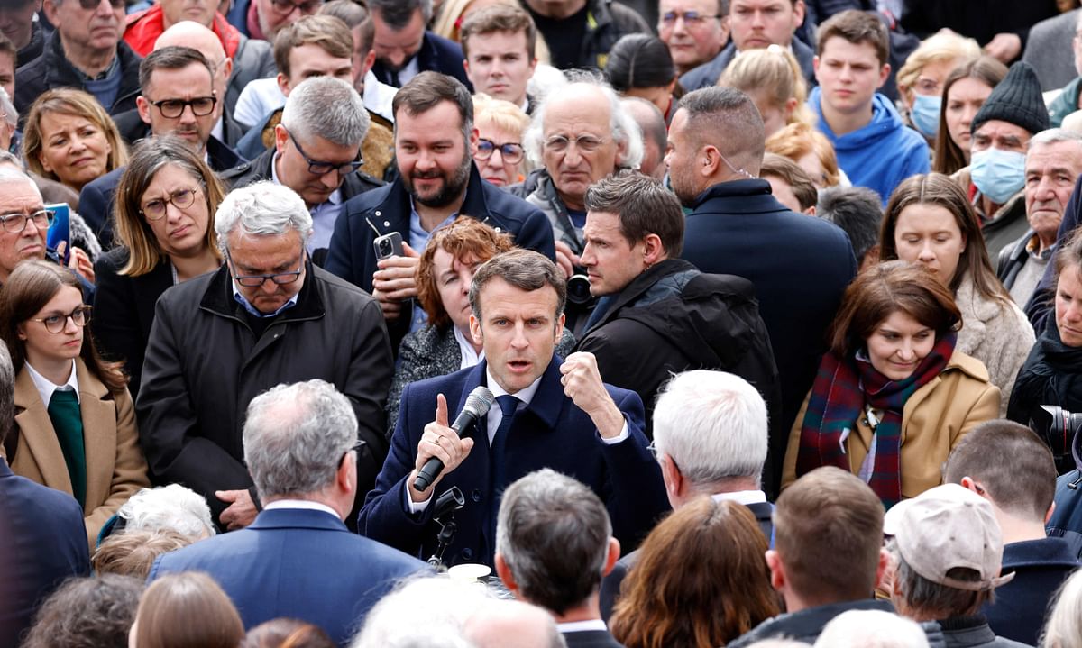 French President and liberal party La Republique en Marche (LREM) candidate for re-election Emmanuel Macron (C) speaks to local residents during a campaign visit in Spezet, western France. Credit: AFP Photo