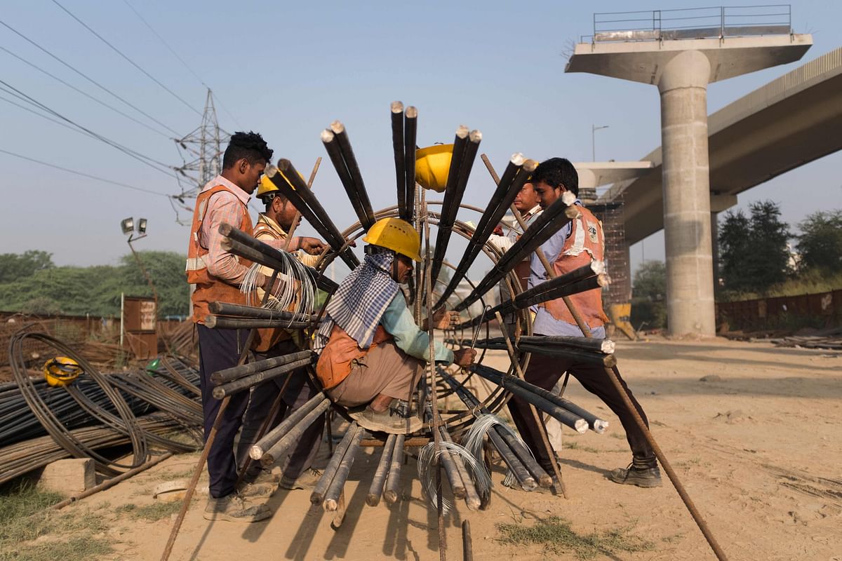 Workers assemble a steel structure at a flyover construction site in New Delhi. Credit: AFP Photo