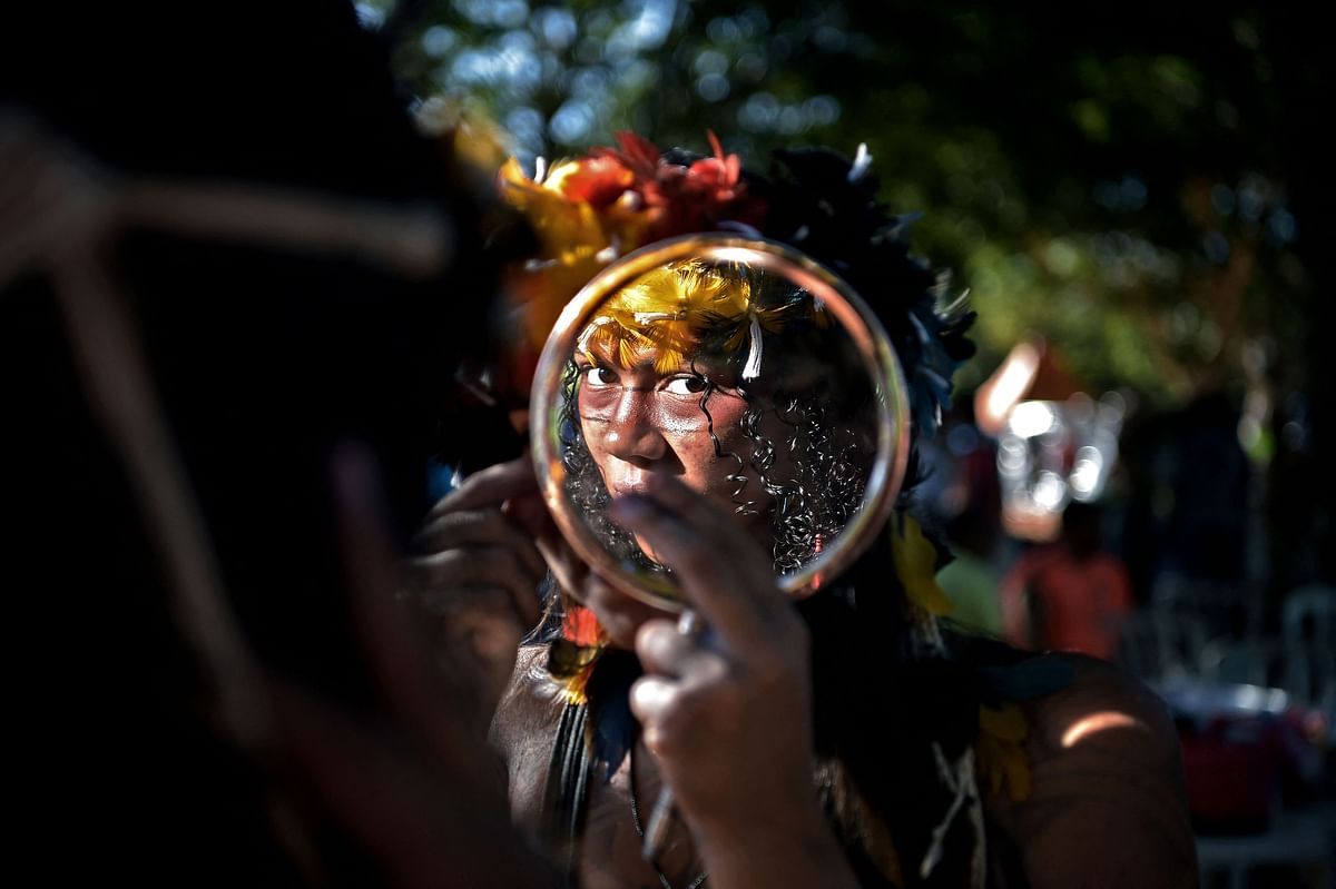 A woman of the Truka tribe looks at herself in the mirror on the fourth day of the Terra Livre Indigenous Camp in Brasilia. Credit: AFP Photo