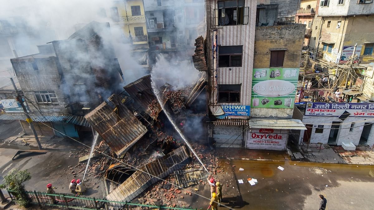 A massive fire broke out in three buildings of Azad market after a cylinder exploded at a shop, injuring five persons. Credit: PTI Photo
