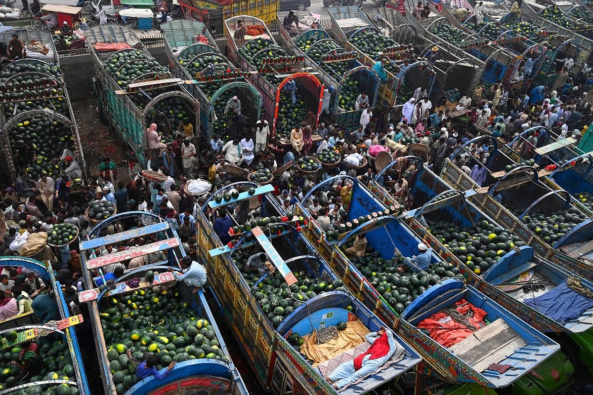 People trade watermelons at a fruit market in Lahore. Credit: AFP Photo