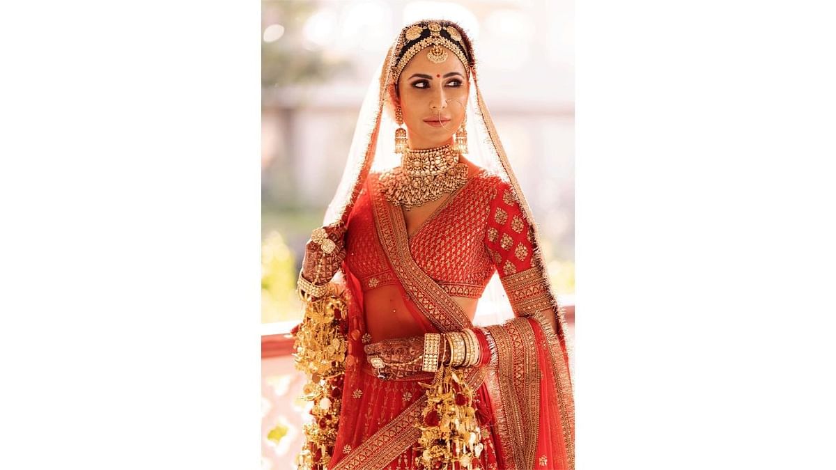 Katrina Kaif, who married actor Vicky Kaushal on December 9, 2021, wore a red Sabyasachi lehenga. In a homage to the groom's Punjabi roots, Kaif's veil was custom-trimmed with handmade Kiran in hand-beaten silver electroplated in gold. Credit: Instagram/katrinakaif