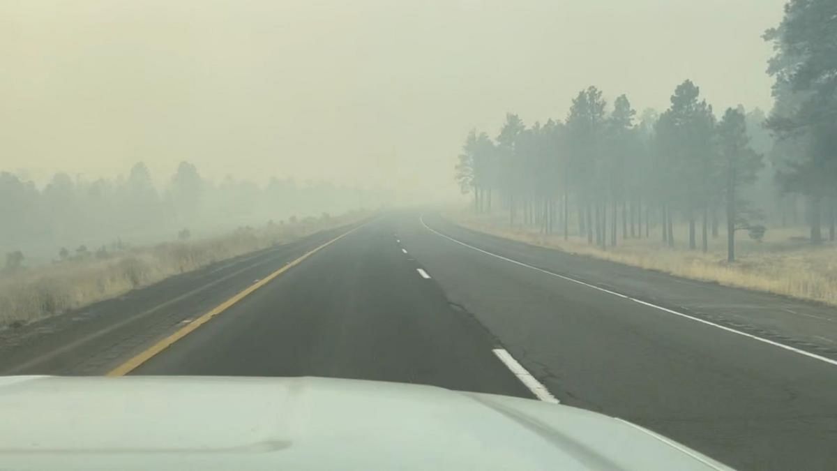 Smoke from a wildfire covers a road in Flagstaff, Arizona, in this screengrab taken from a social media video. Credit: Arizona Department of Transportation/Reuters photo