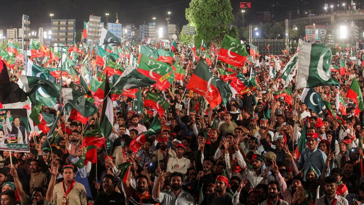Supporters of the Pakistan Tehreek-e-Insaf (PTI) political party wave party flags as they gather to listen the speech of the ousted Pakistani Prime Minister Imran Khan during a rally, in Lahore. Credit: Reuters photo