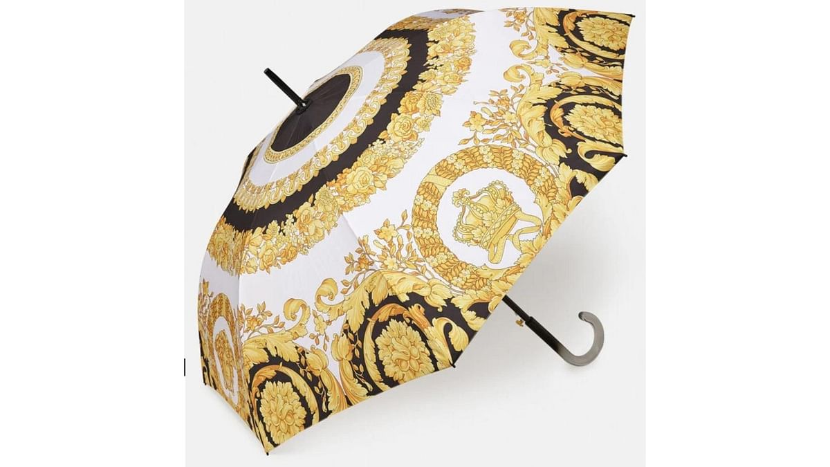 Barocco print: The Barocco print umbrella from Versace would be an essential item on a gloomy day. Priced at Rs 25,100, this 90-cm piece has a classic handle with a colour fade effect. Credit: Farfetch.com