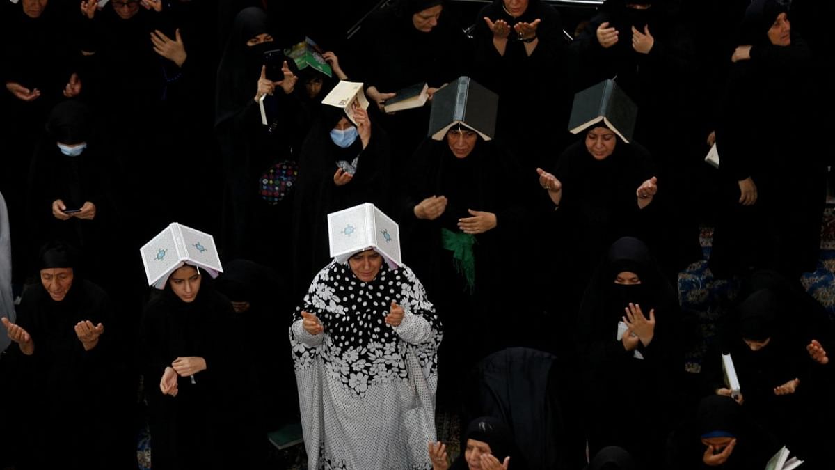 Iraq Shi'ite muslims place copies of the Quran on their heads during the holy month of Ramadan at the Imam Ali Shrine, in the holy city of Najaf, Iraq. Credit: Reuters photo
