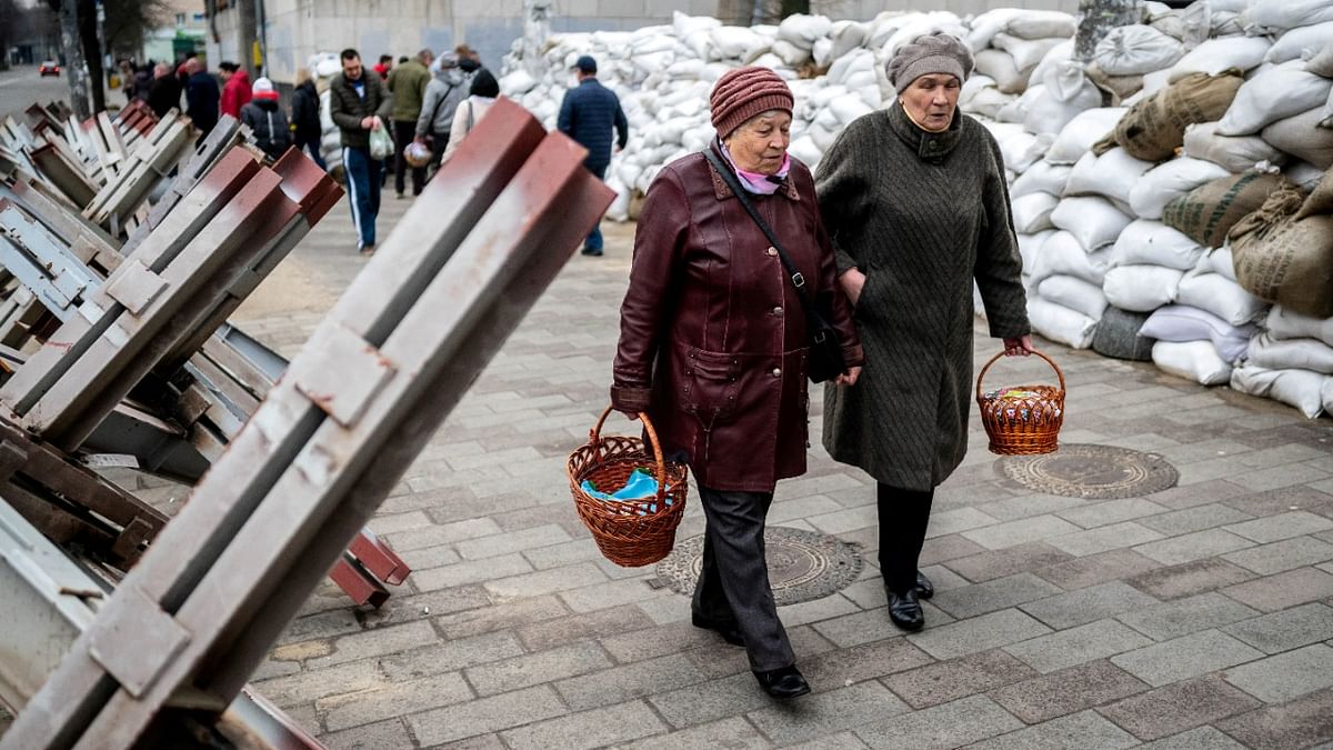 Faithful walk between sandbags and hedgehog anti-tank barricades to attend a blessing of traditional Easter food baskets on Holy Saturday, amid Russia's invasion of Ukraine, in Zhytomyr, Ukraine. Credit: Reuters Photo