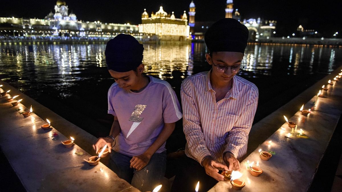Sikh devotees light diya or earthen lamps on the occasion of birth anniversary of Guru Amar Das Ji, the third guru of the Sikhs, at the Golden Temple in Amritsar. Credit: AFP Photo