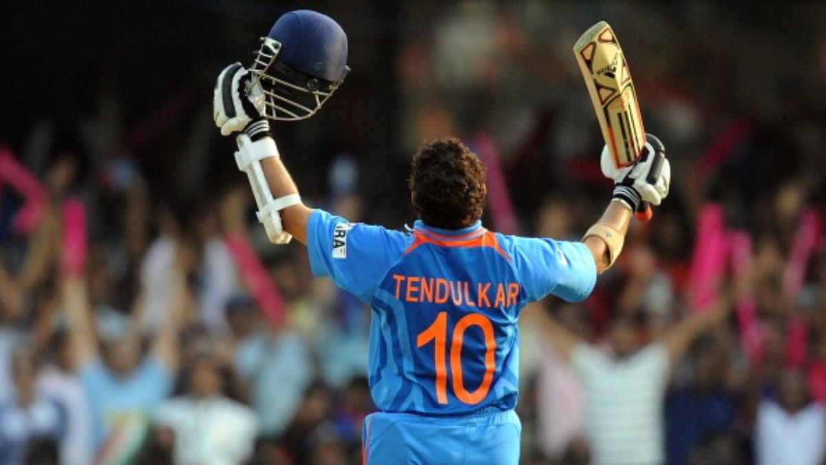 Sachin raises his bat to celebrate his century during Cricket World Cup match between England and India at The M Chinnaswamy Stadium in Bangalore on February 27, 2011. Credit: AFP/Getty Images