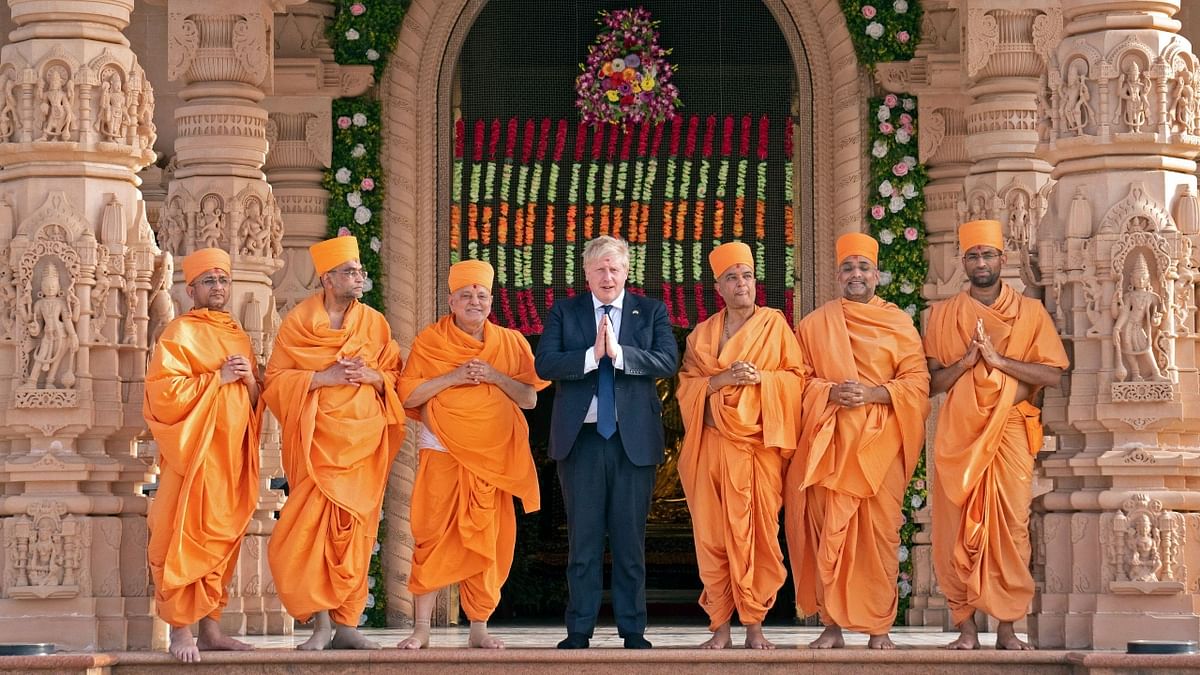 UK PM flanked by sadhus in front of the Swaminarayan Akshardham temple. Credit: AFP Photo