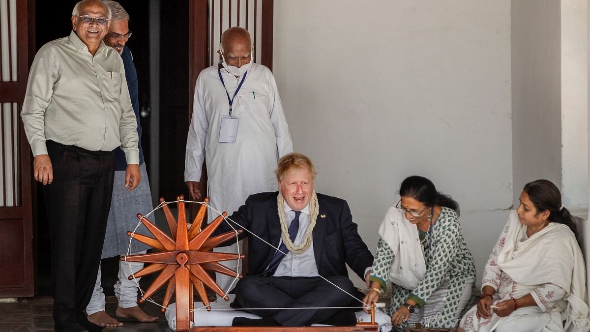 UK PM Johnson headed to Sabarmati Ashram where he tried his hand at a spinning wheel. Credit: PTI Photo