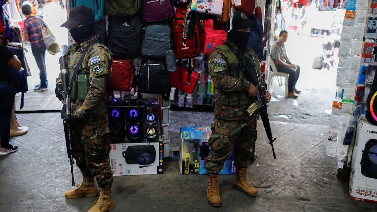 Soldiers stand guard at an exit of a market in downtown San Salvador after El Salvador's Congress extended emergency powers to fight gangs for one more month. Credit: Reuters Photo
