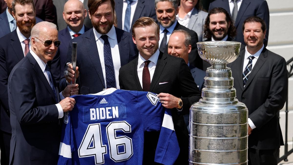 President Joe Biden (L) is presented with an honorary jersey and a silver stick by Tampa Bay Lightning defenseman Victor Hedman (M) and Lightning center Steven Stamkos (R) during a ceremony honoring the Stanley Cup champion Tampa Bay Lightning on the South Lawn at the White House. Credit: Geoff Burke/USA Today Sports