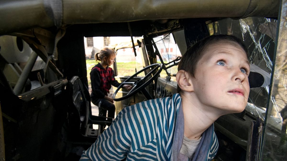 Local boy Faddei plays in a destroyed Russian military truck in the village of Kolychivka, in Chernihiv region, Ukraine. Credit: Reuters File Photo