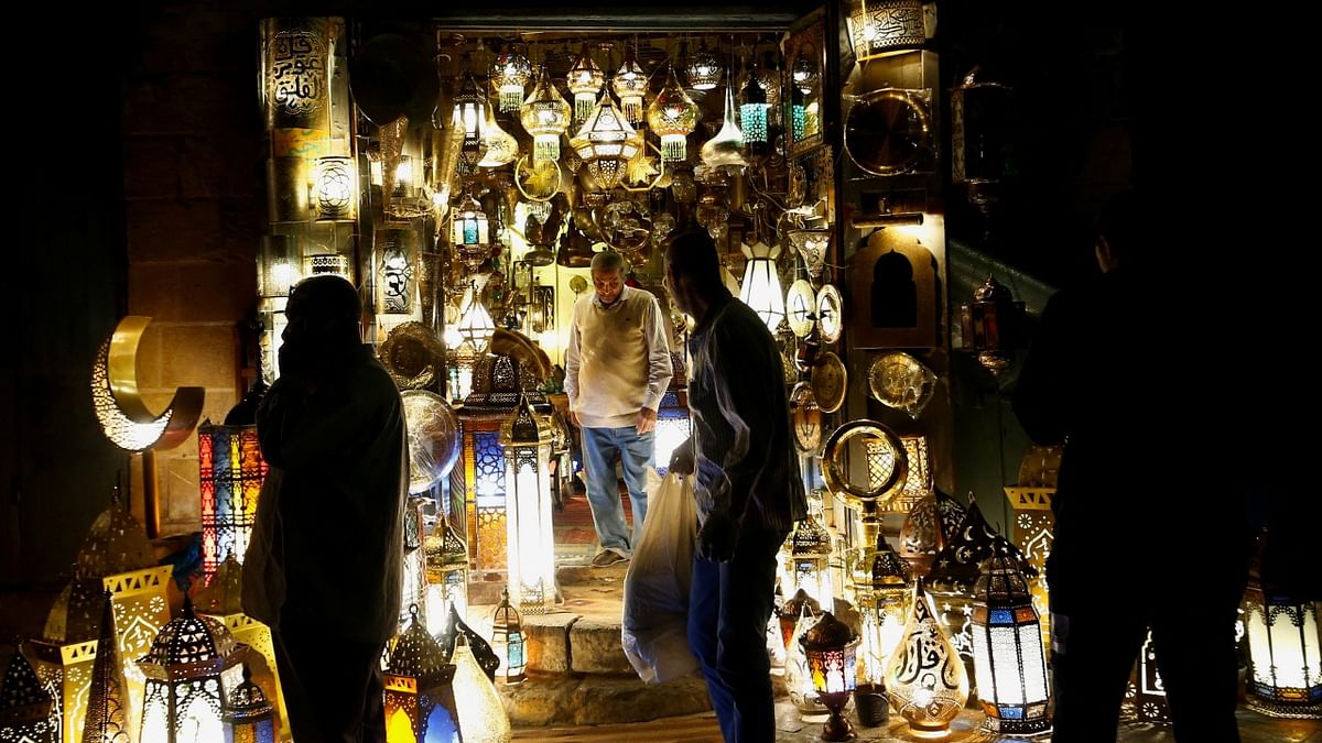 People walk next to Islamic and Arabian goods lit with traditional lanterns during the holy fasting month of Ramadan at a popular tourist area in the Khan el-Khalili market, in old Islamic Cairo, Egypt. Credit: Reuters Photo
