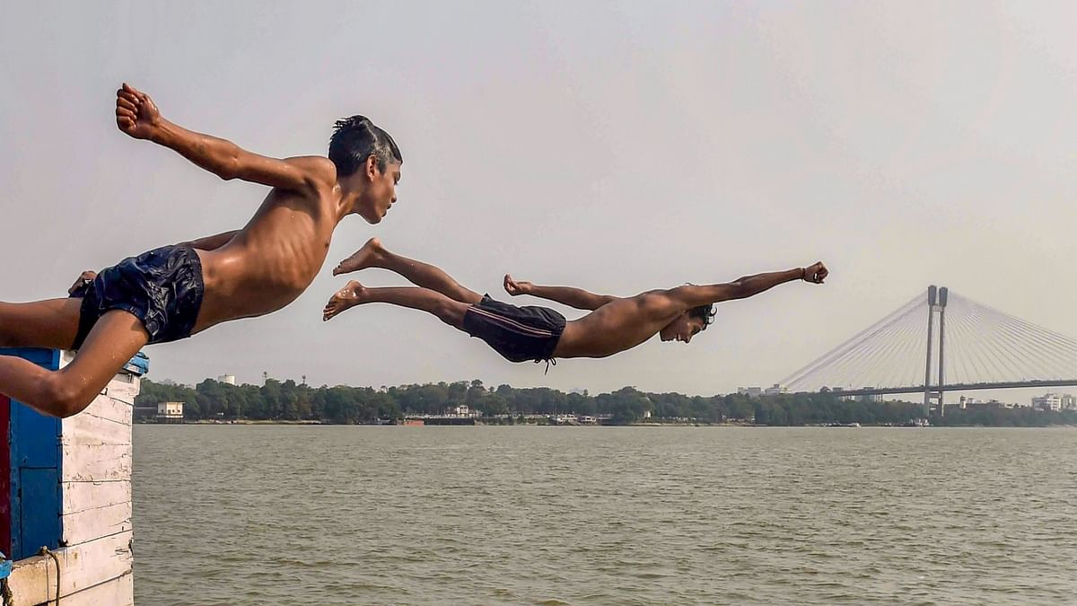 Boys jump into the Ganga River to beat the heat during a hot summer day, in Kolkata. Credit: PTI Photo