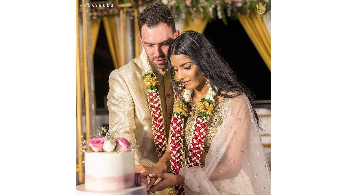 Glen Maxwell and Vini Raman are seen cutting the cake during their post-wedding party. Credit: RCB
