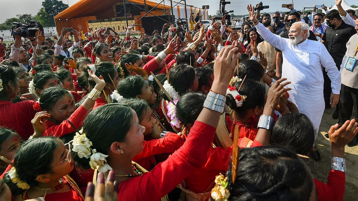 In this photo, PM Modi is seen greeting his supporters during his visit to Assam. Credit: PTI Photo