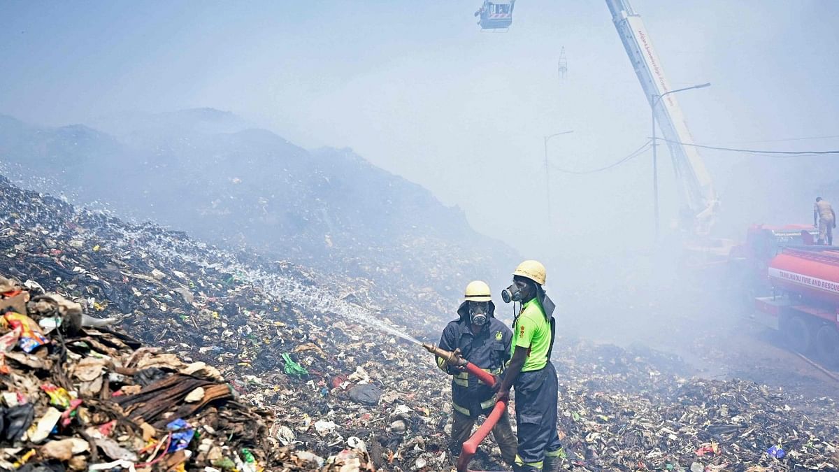 Firefighters try to extinguish burning garbage after a fire broke out at the Perungudi landfill in Chennai. Credit: AFP Photo