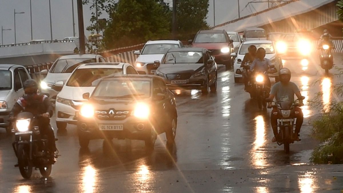 Vehicles plying in the rains in New Delhi. Credit: PTI Photo