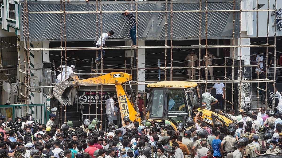 An illegal encroachment, an iron structure in front of a building, was manually removed by the people during the proposed demolition drive in Delhi's Shaheen Bagh. Credit: PTI Photo