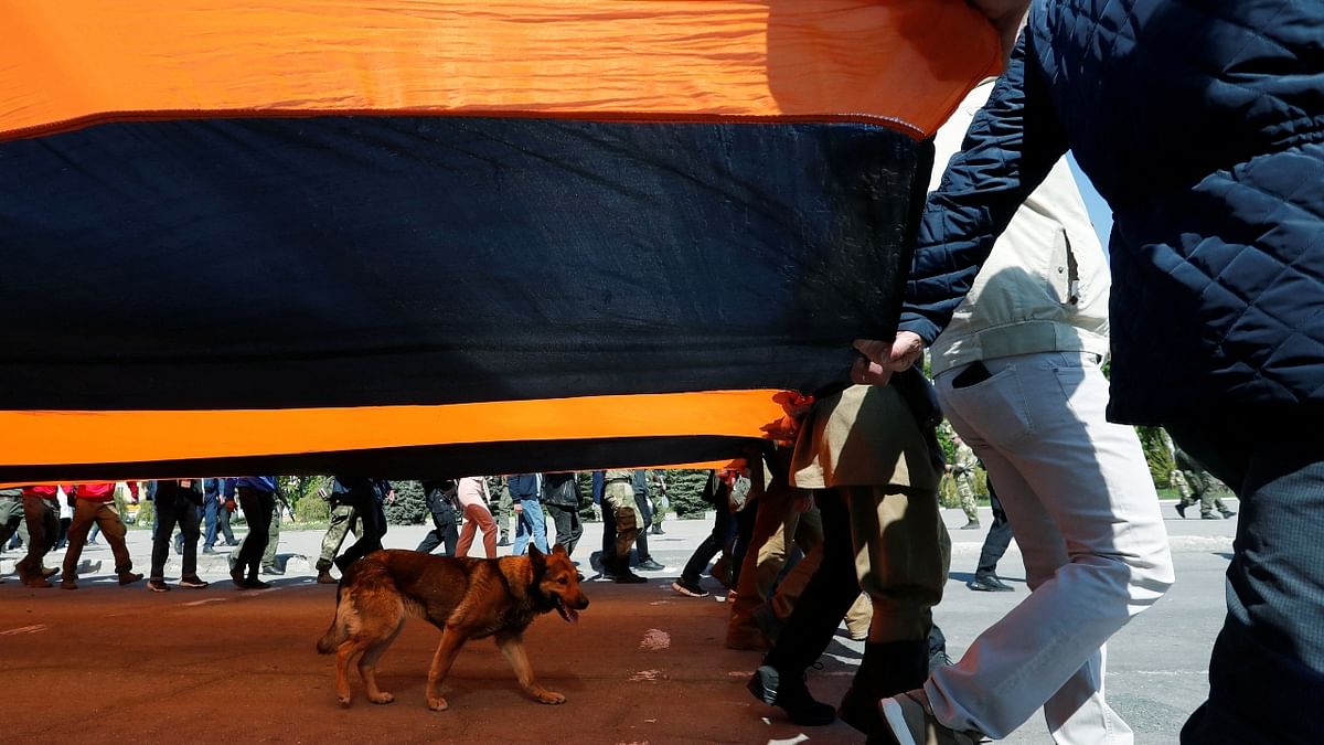 In the devastated southern port of Mariupol, pro-Russian separatists feted Victory Day, with leader Denis Pushilin and residents carrying a giant black and orange ribbon of Saint George -- a symbol of WWII celebrations in Russia -- through a city that has seen some of the heaviest fightings since the invasion on February 24. Credit: Reuters Photo