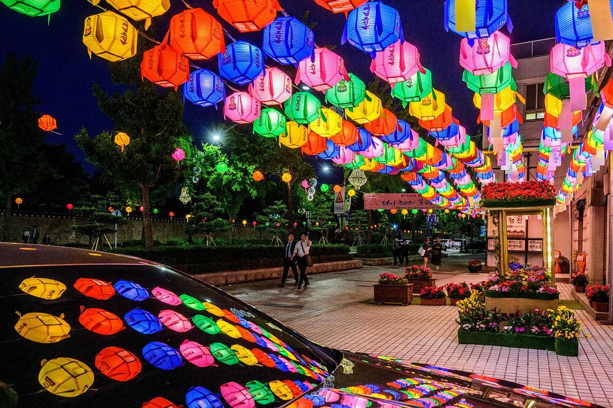 Pedestrians walk past a display of lotus lanterns outside the Beomnyeonsa Temple, a Buddhist temple in Seoul. Credit: AFP Photo