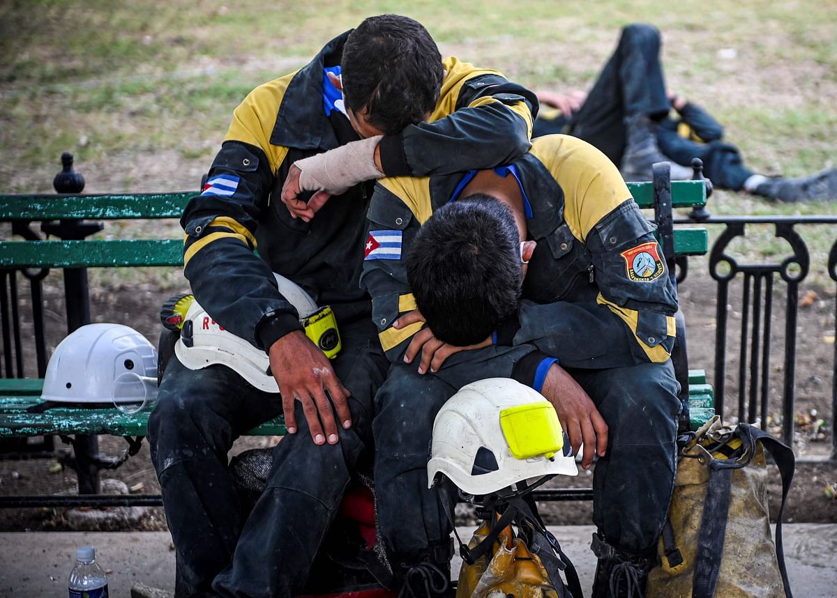 Members of the rescue brigade rest after a work shift at the Saratoga Hotel days after a huge blast wrecked the building, in Havana. Credit: AFP Photo