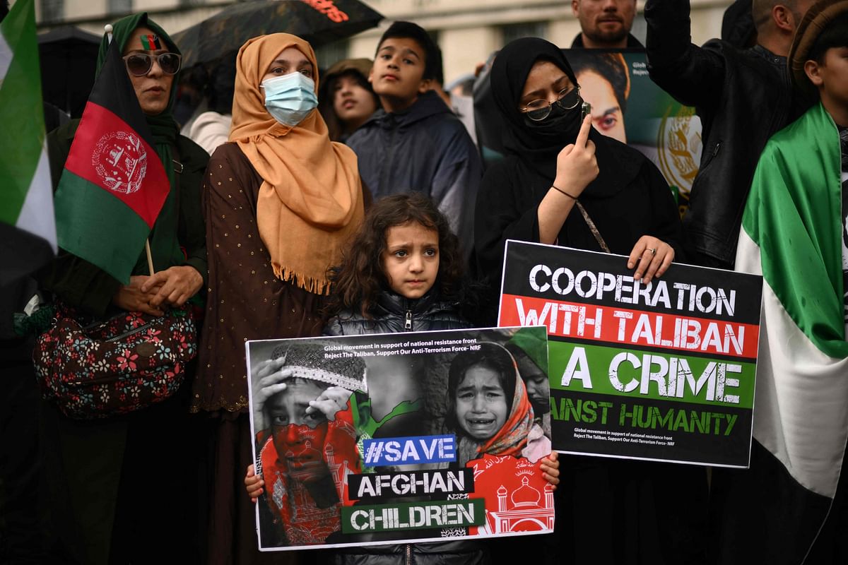 Demonstrators hold placards at a protest in front of the Downing Street gates, in central London. Credit: AFP Photo