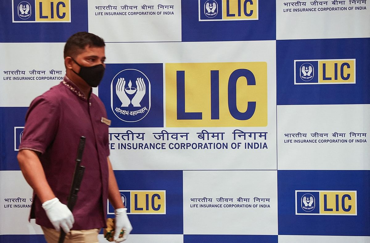 A man walks past a hoarding of LIC after the press conference of the LIC IPO launch, in Mumbai. Credit: Reuters Photo