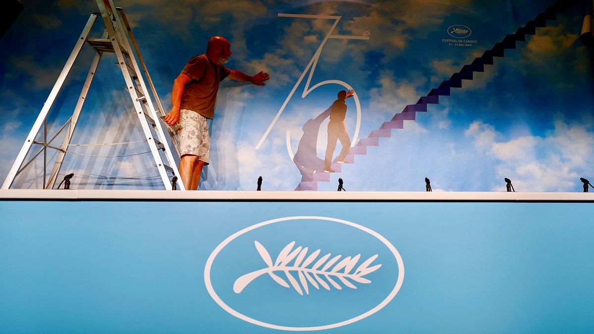 A worker gives the last touches to the official poster of the 75th Cannes Film Festival ahead of the opening ceremony in Cannes, France. Credit: Reuters Photo