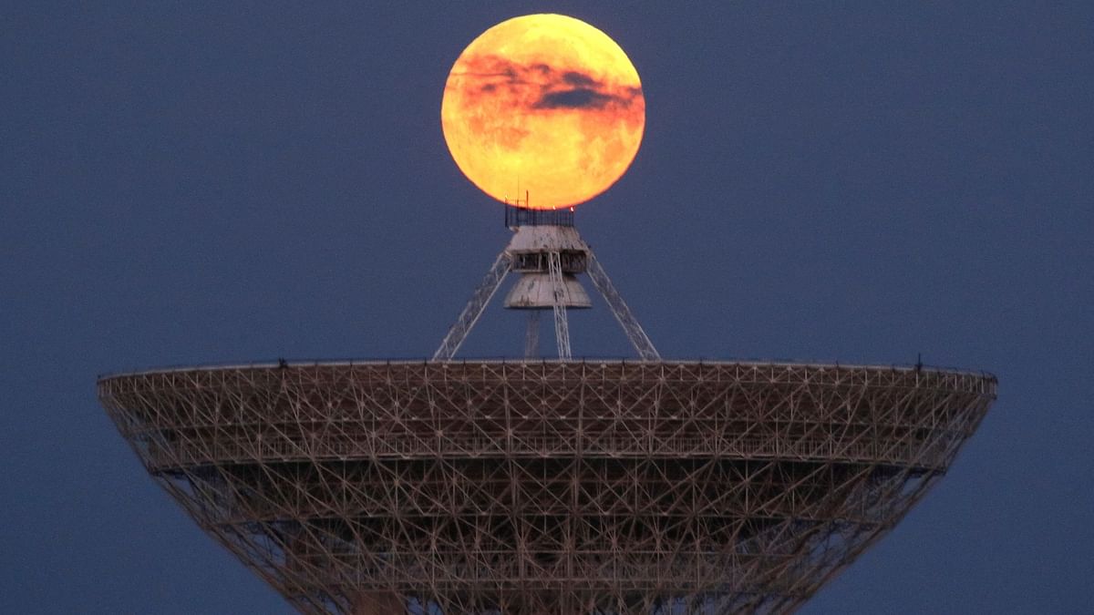 The moon is seen through clouds behind the radio telescope RT-70 in the village of Molochnoye, Crimea. Credit: Reuters Photo