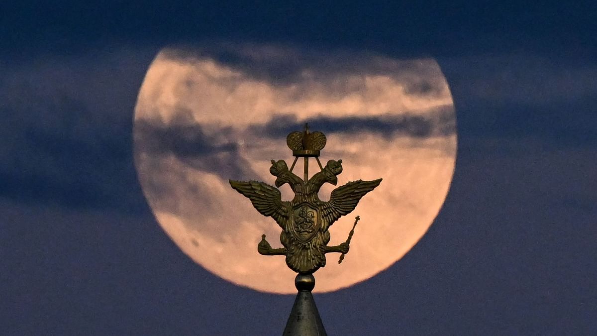 The full moon also known as Flower blood moon is pictured behind the two-headed eagle, the national symbol of Russia atop a building on Red Square in downtown Moscow. Credit: AFP Photo