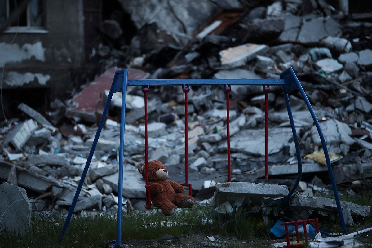 A teddy bear hangs on a swing next to a damaged building in Saltivka district, amid Russia's attack on Ukraine. Credit: Reuters Photo