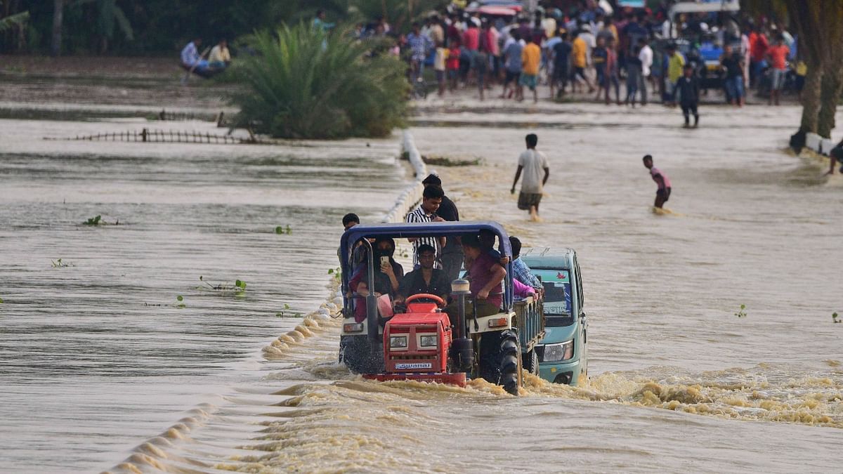 A tractor was used to transport flood-affected villagers at Jamunamukh village in Nagaon, Assam. Credit: PTI Photo