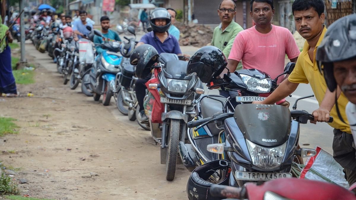 Long queues were witnessed outside fuel stations due to the Assam-Tripura road blockade. In this photo, Motorcyclists are seen waiting for refilling at a fuel station in Agartala. Credit: PTI Photo