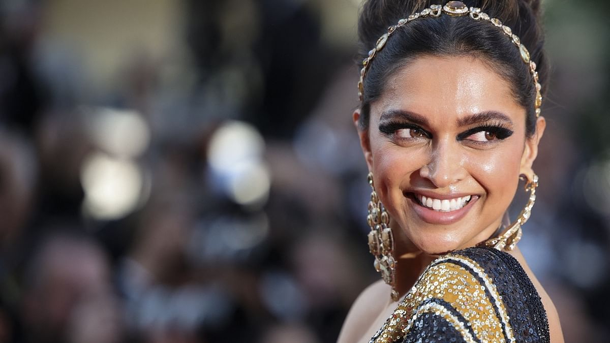 Actor Deepika Padukone flashes her million-dollar smile as walks the red carpet. Credit: AFP Photo