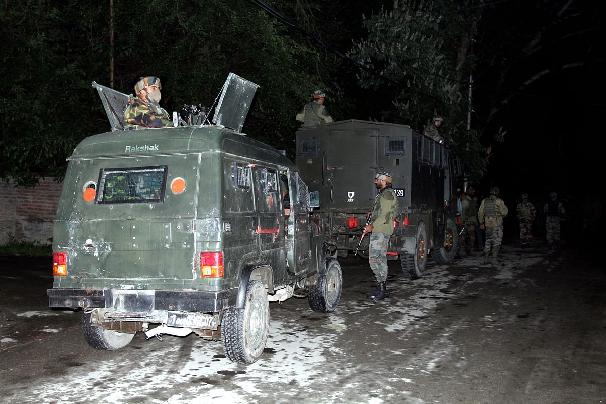 Security personnel cordon off the area to conduct a search operation after a grenade was hurled at a newly opened wine shop, in Jammu and Kashmir's Baramulla district. Credit: PTI Photo