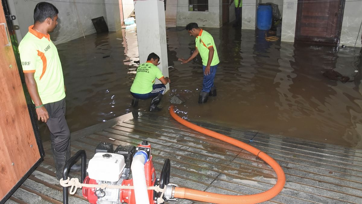 Families living in low-lying areas struggled to remove rain water that gushed into their houses. Credit: PTI Photo