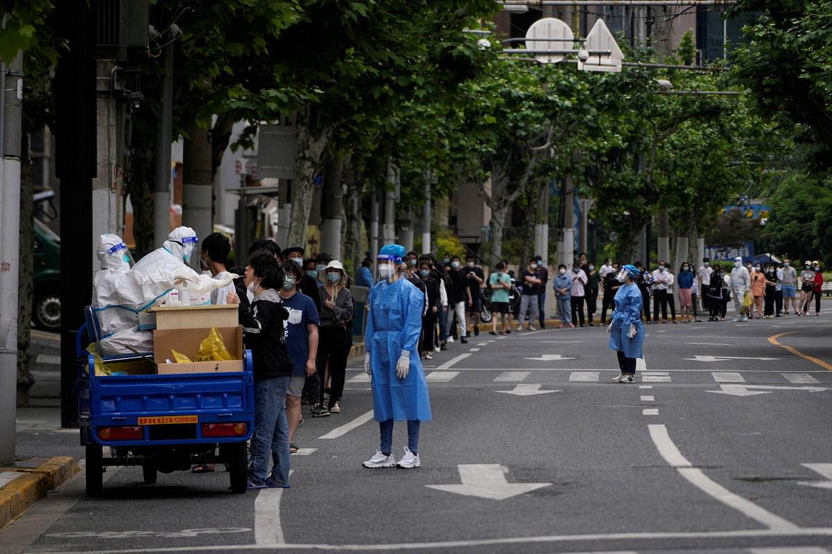 Residents line up for nucleic acid tests on a street during lockdown, amid the coronavirus disease pandemic, in Shanghai, China. Credit: Reuters Photo