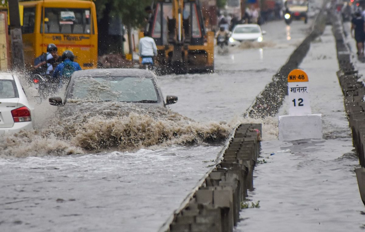Vehicles wade through the waterlogged service road of the Delhi-Gurugram expressway after heavy rains. Credit: PTI Photo