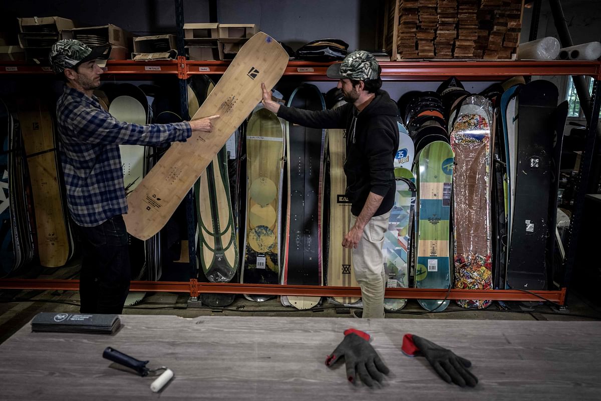The two co-founders of Nok Boards, Adrien Reguis, 41-years-old, (L) and Vincent Gelin, 32-years-old move boards in their workshop where they transform old snowboard into a high-end and eco-responsible skateboard, in their small workshop, in the suburbs of the city of Grenoble, southeastern France. Credit: AFP Photo